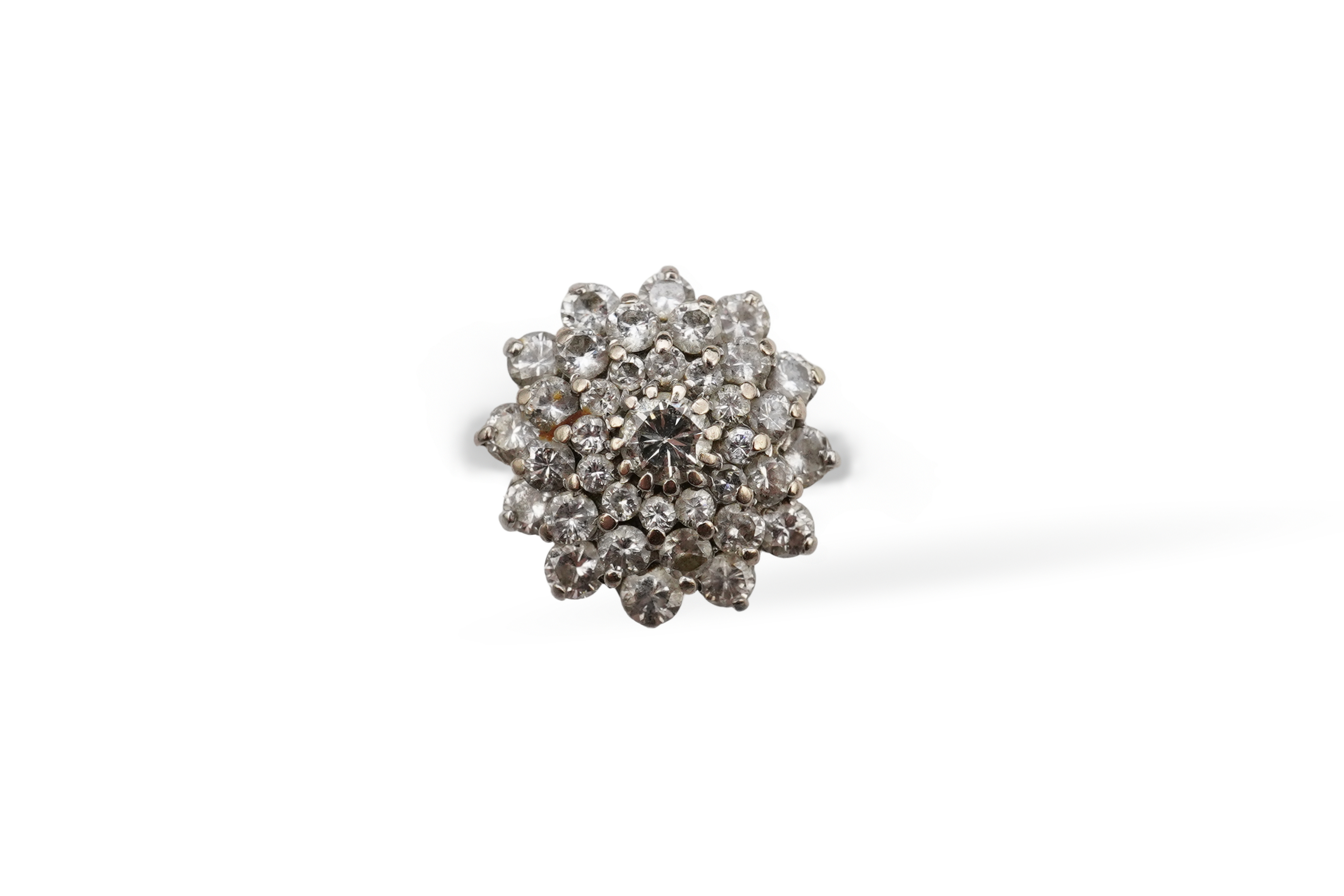 A white gold and diamond cluster ring, set with a concentric arrangement of brilliant-cut diamonds totalling approximately 1.50 carats, size M, gross weight approximately 5 grams